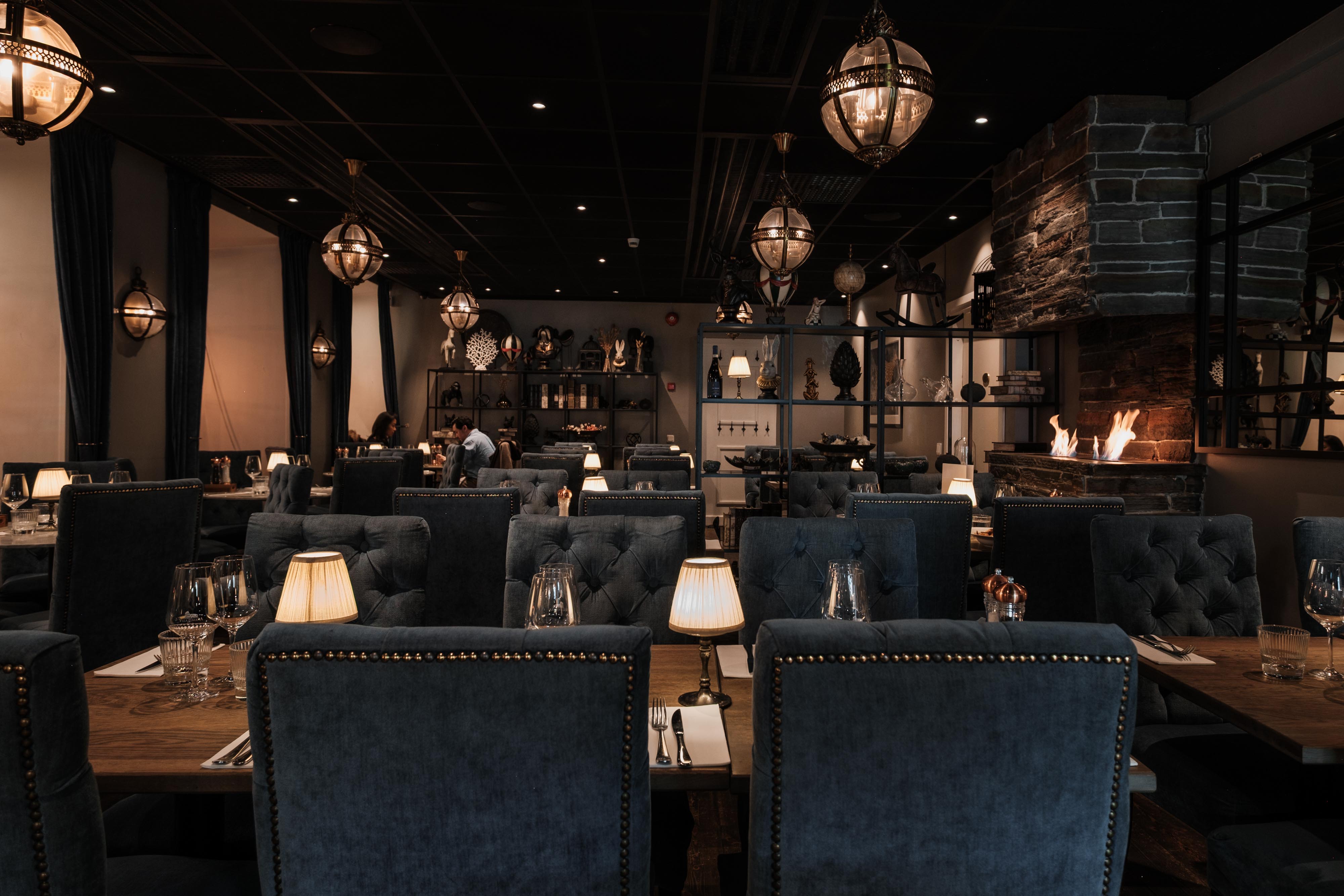 The Villa Romana dining room with lanterns, an open fire and tables set for dinner