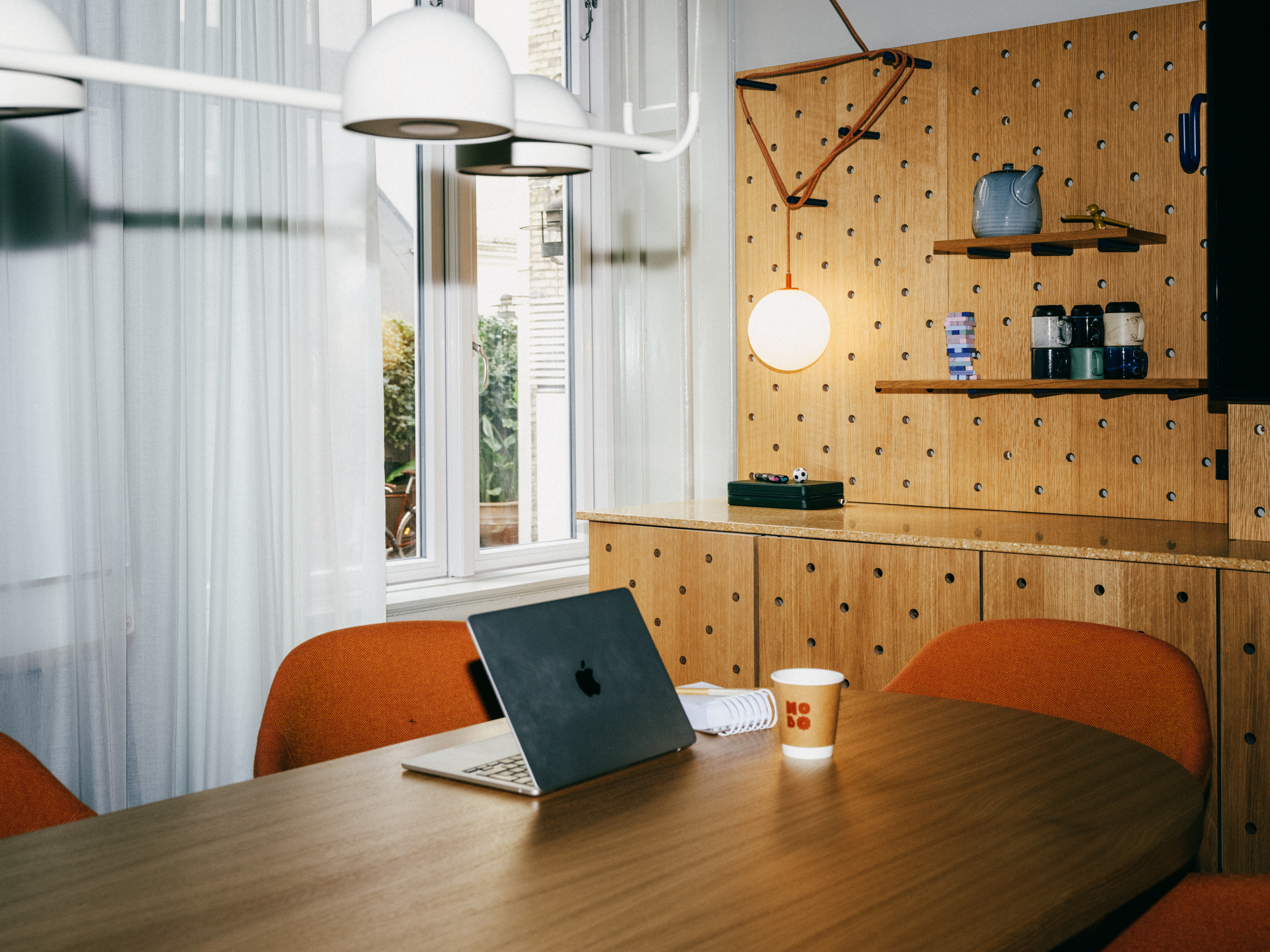 Laptop on wooden table in cozy cafe.