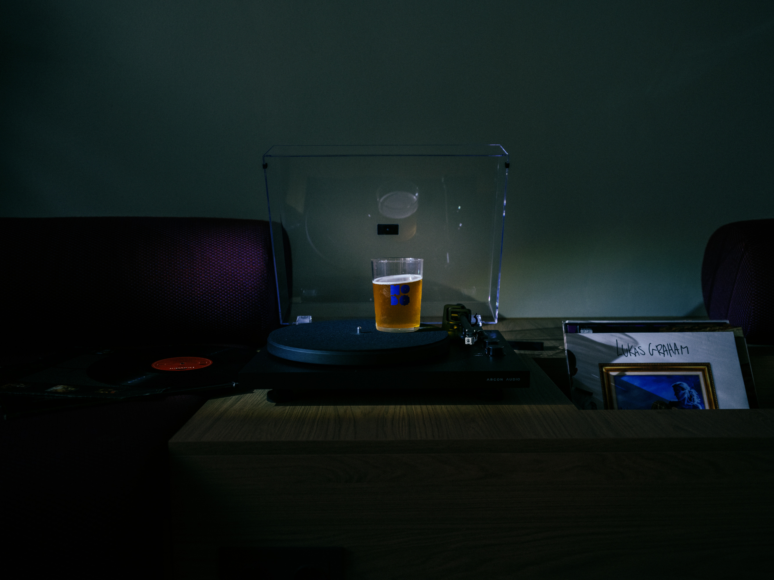 A vinyl player holds a beer.