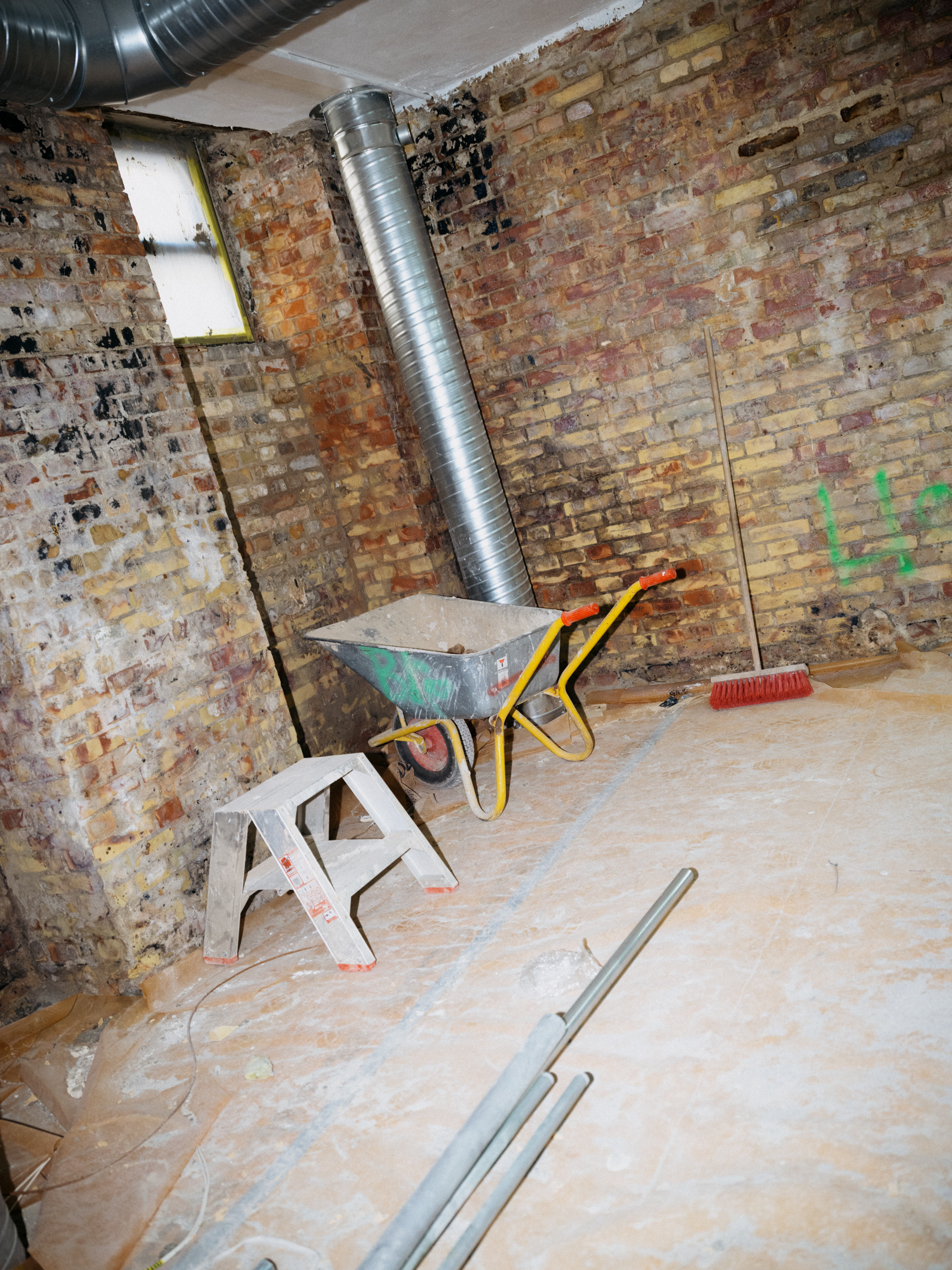 Construction site with brick walls, a ladder and a wheelbarrow