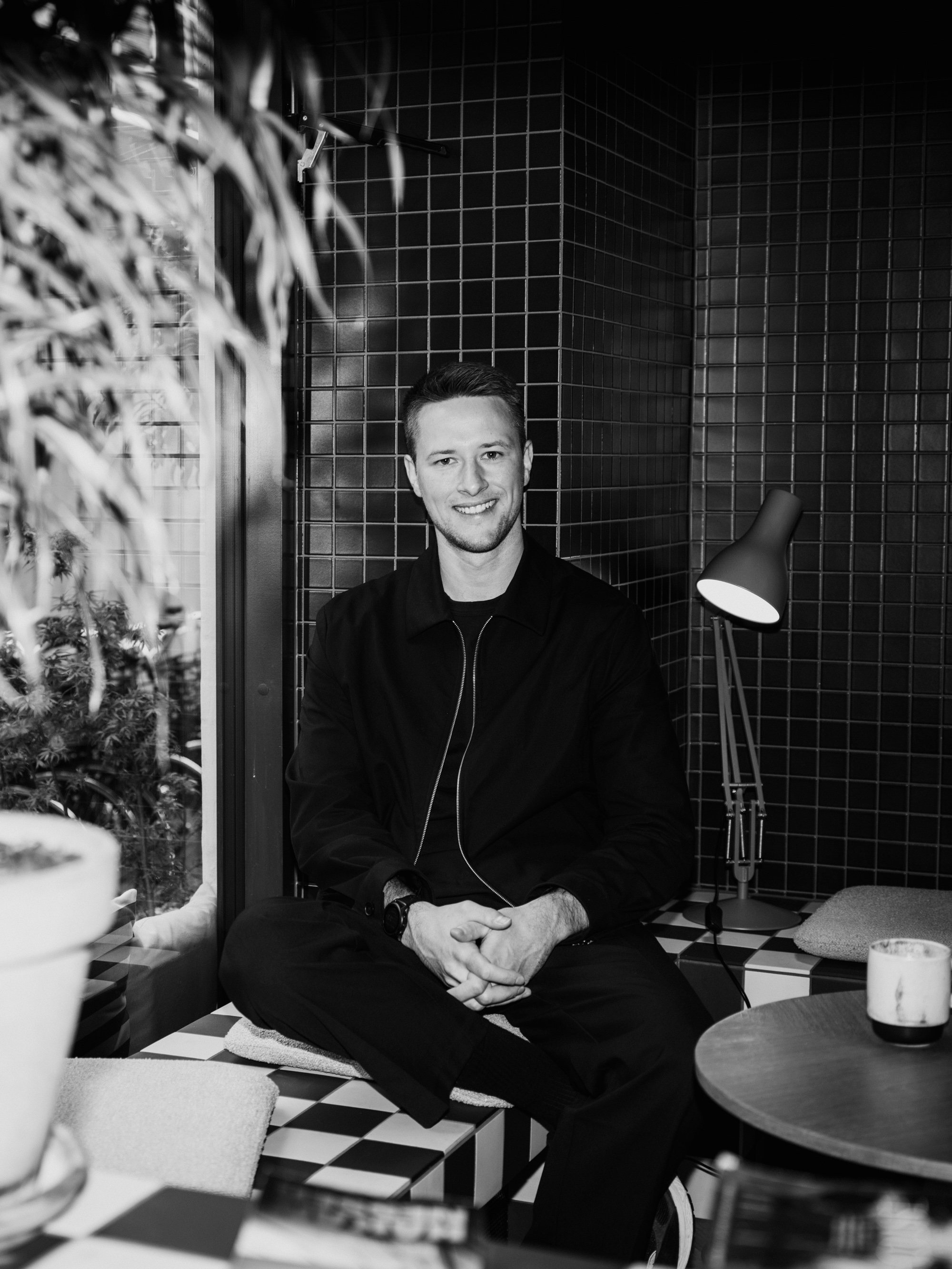 A man sits and smiles in a modern room.
