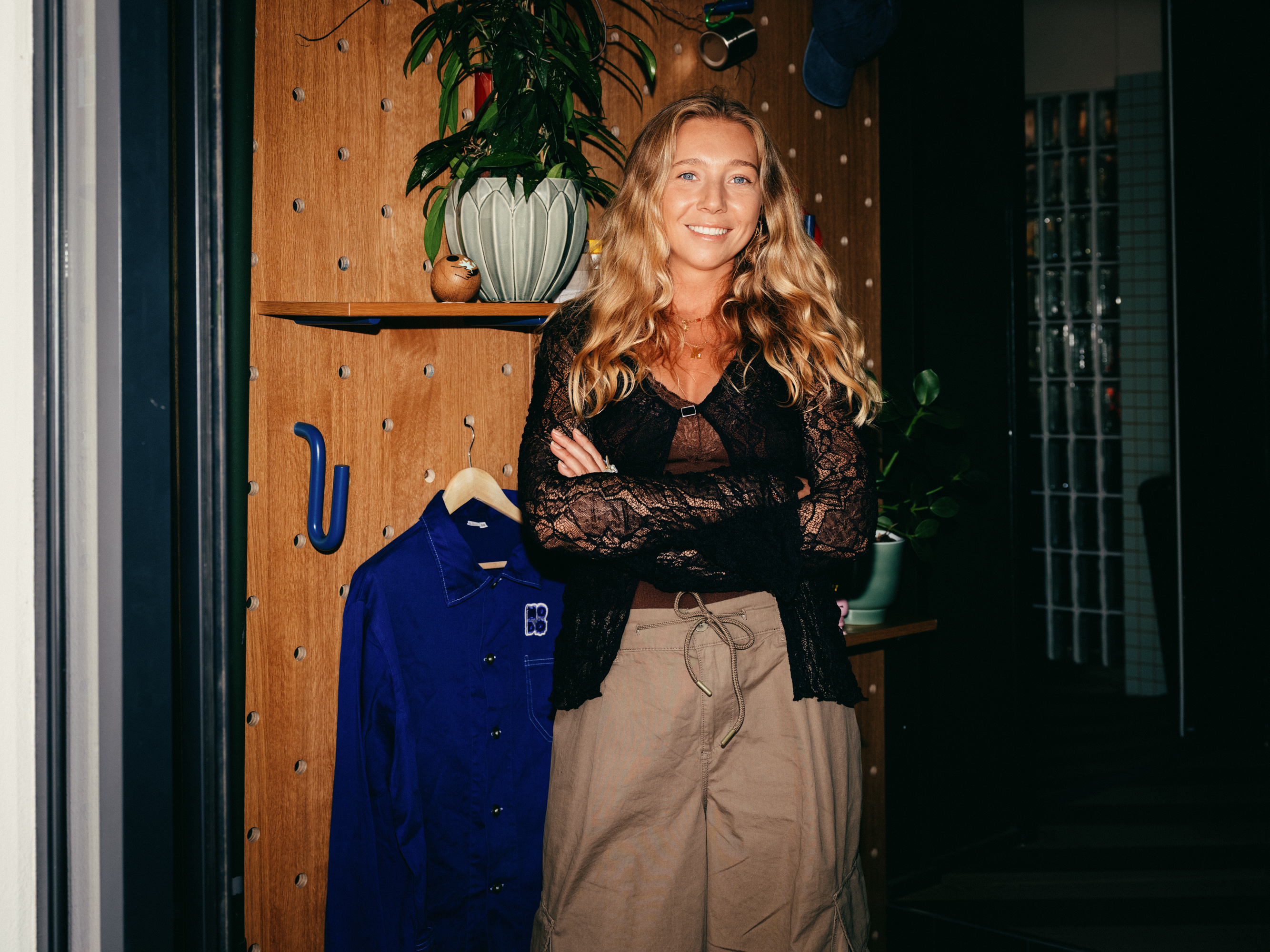 Woman in a lace top smiling in front of the Hobo peg wall