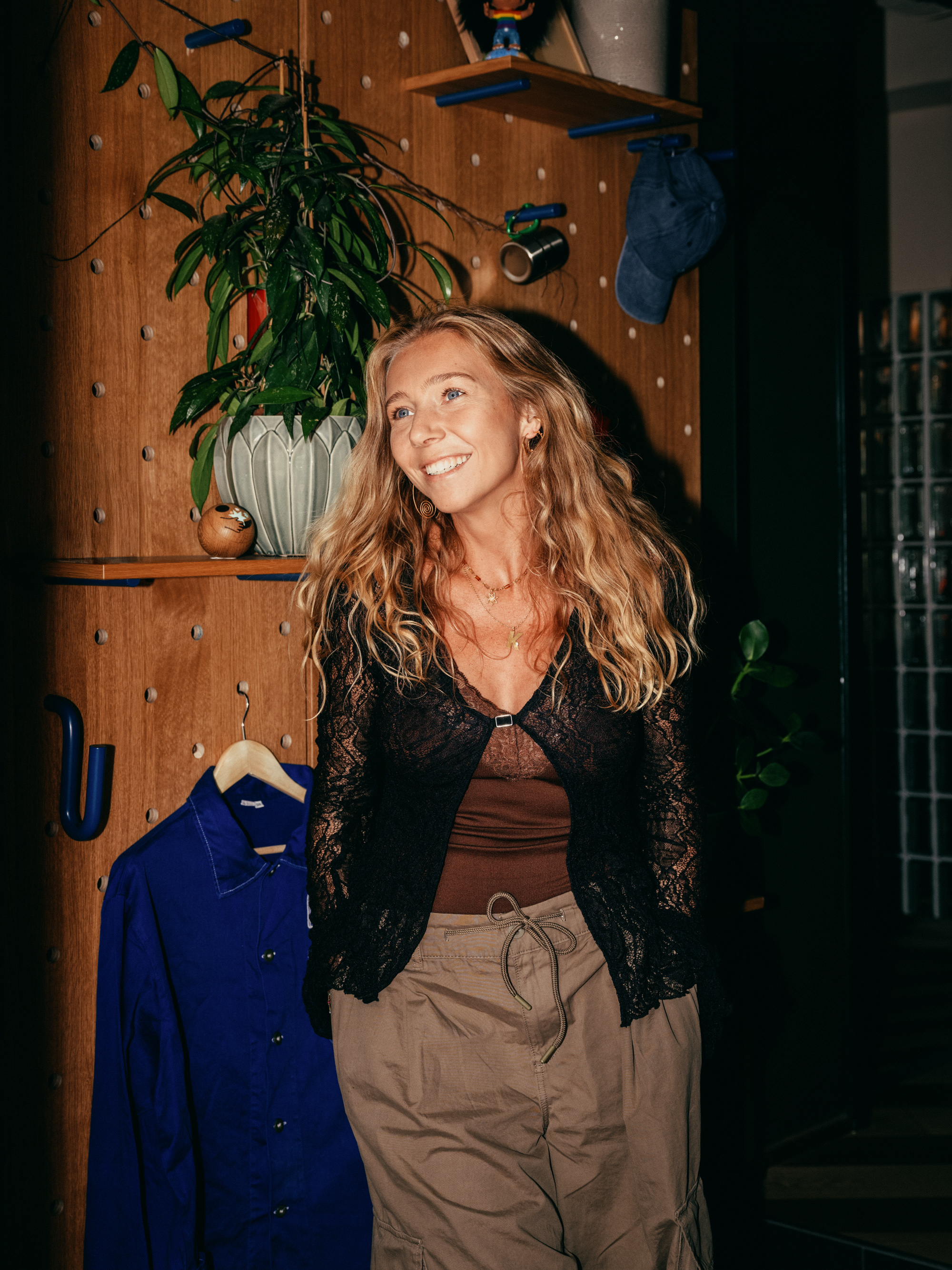 Young woman standing indoors, facing forward.