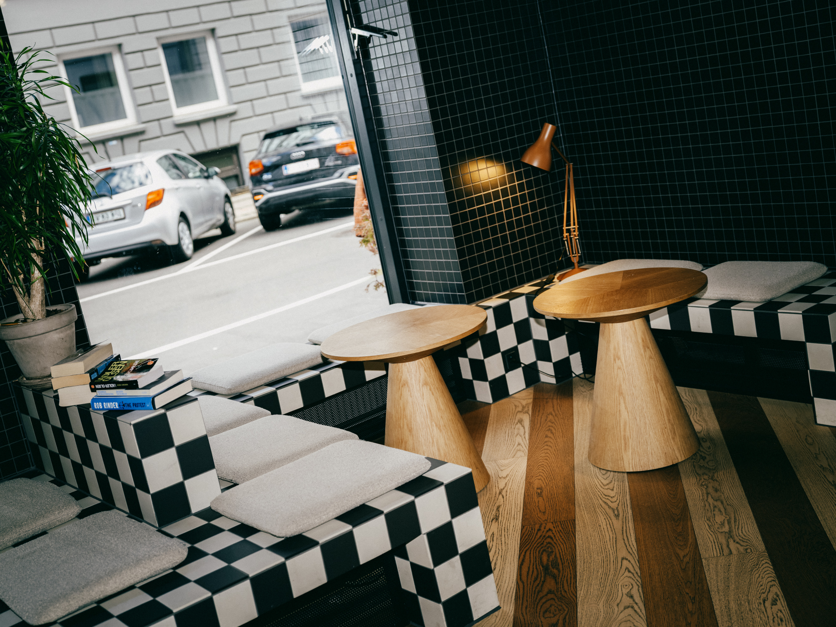 Lounge by the window with checkered cushions and wooden stools