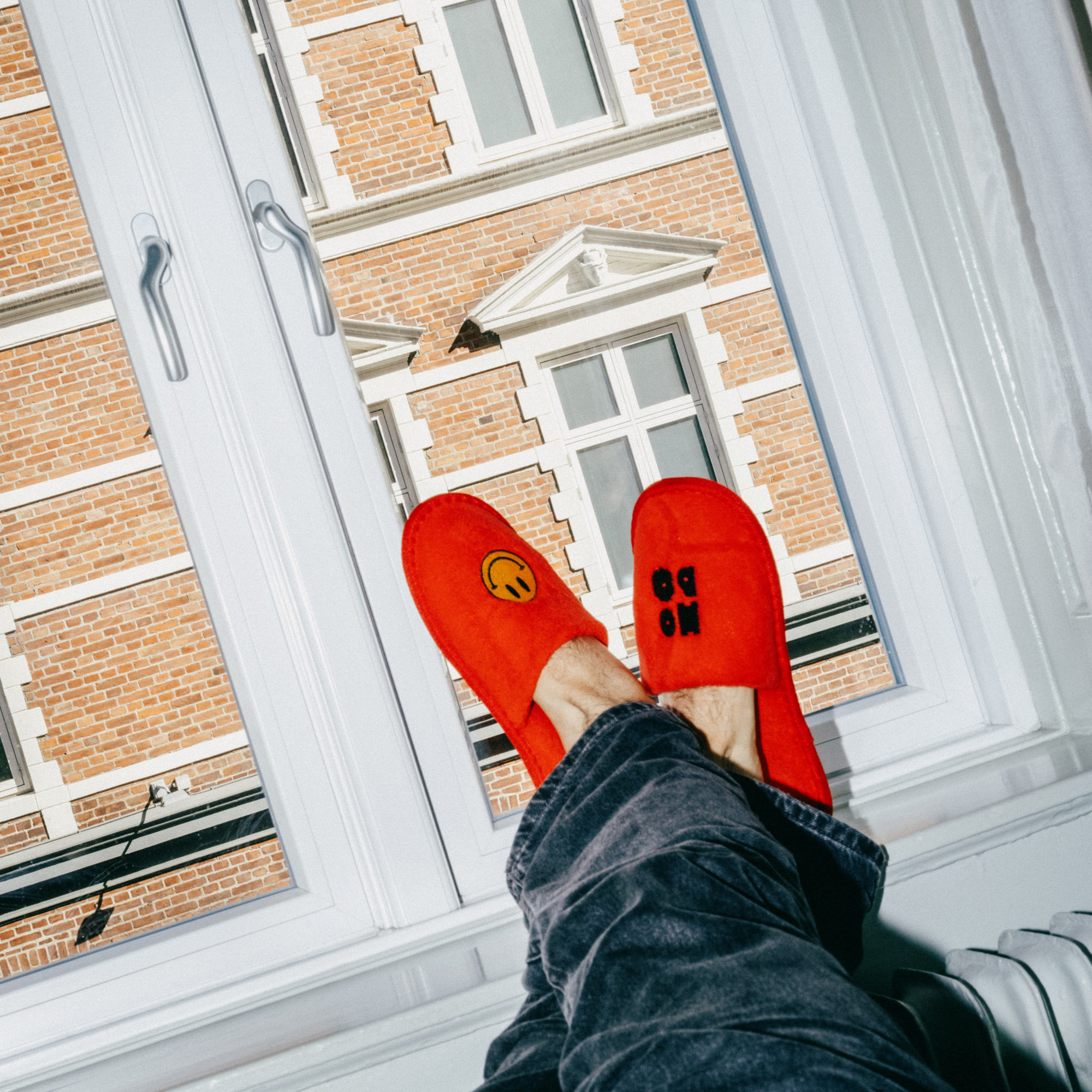 Feet in red Hobo slippers resting in the window
