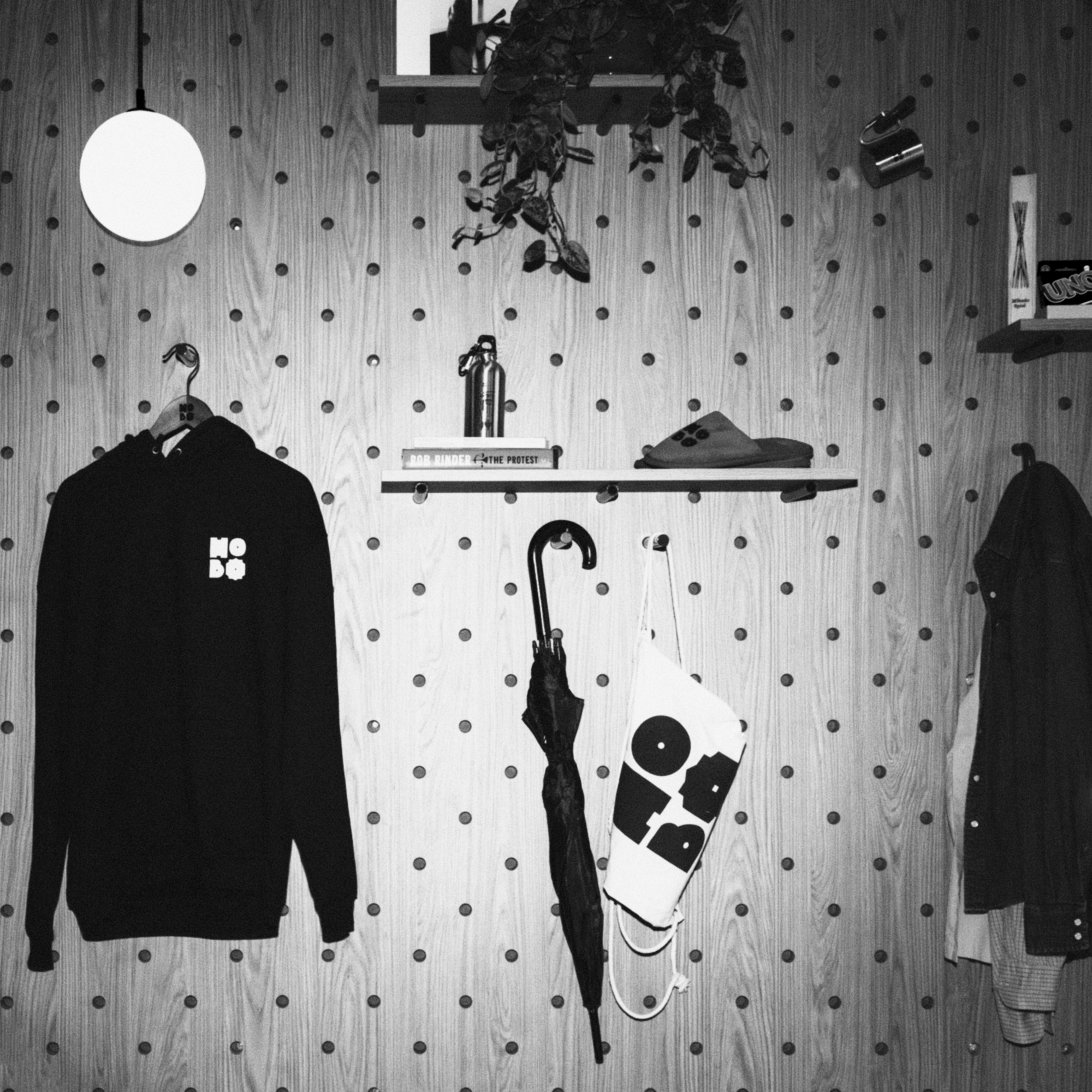 Peg wall with a Hobo hoodie, umbrella and tote bag, in black and white