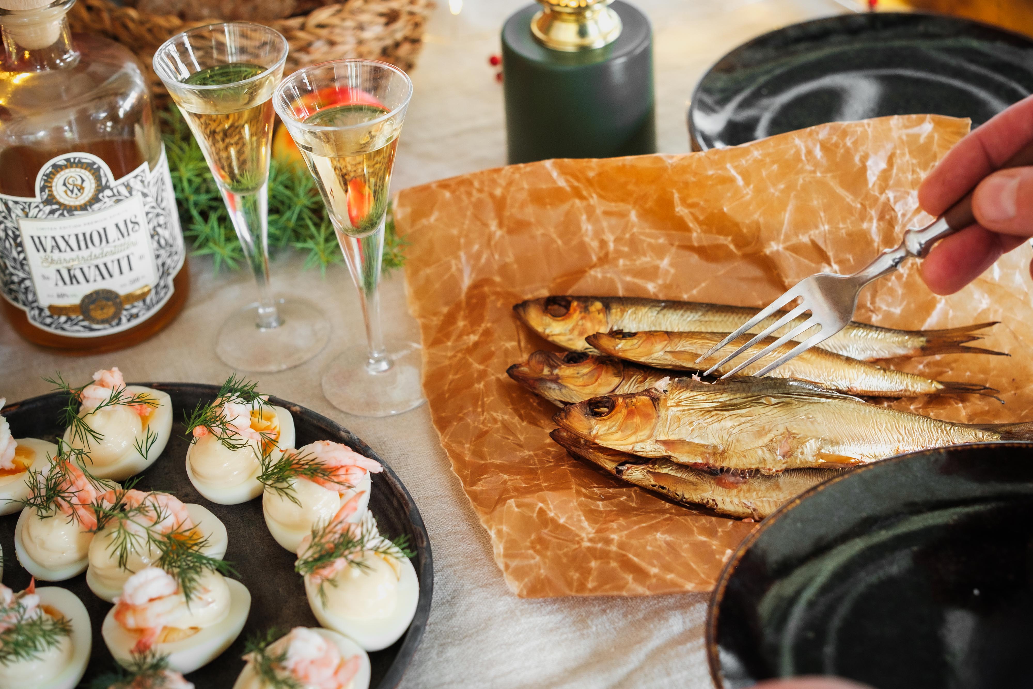 En person vänder eller serverar rökt fisk med gaffel.