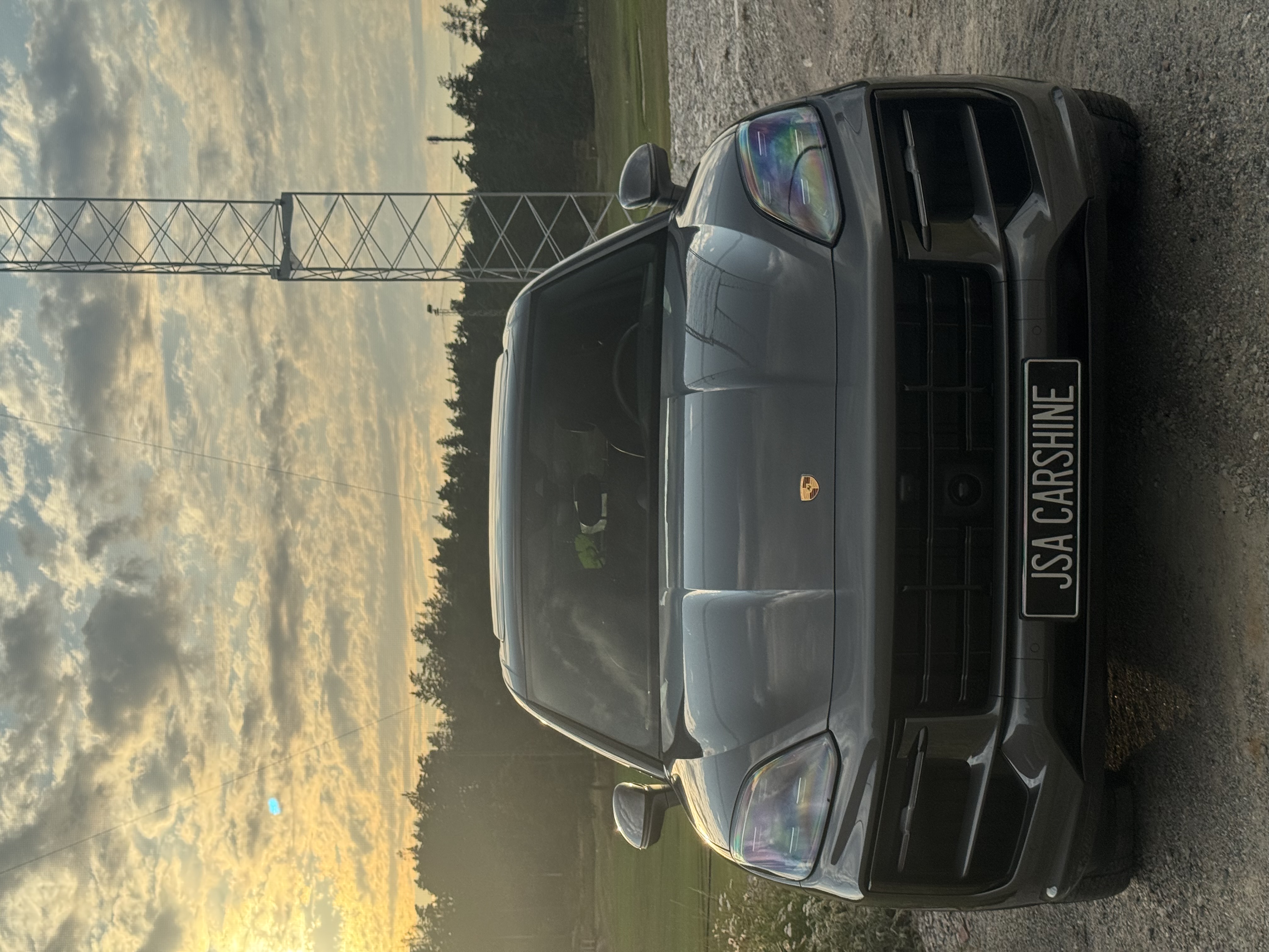 Porsche Cayenne med JSA Carshine-skylt i solnedgång